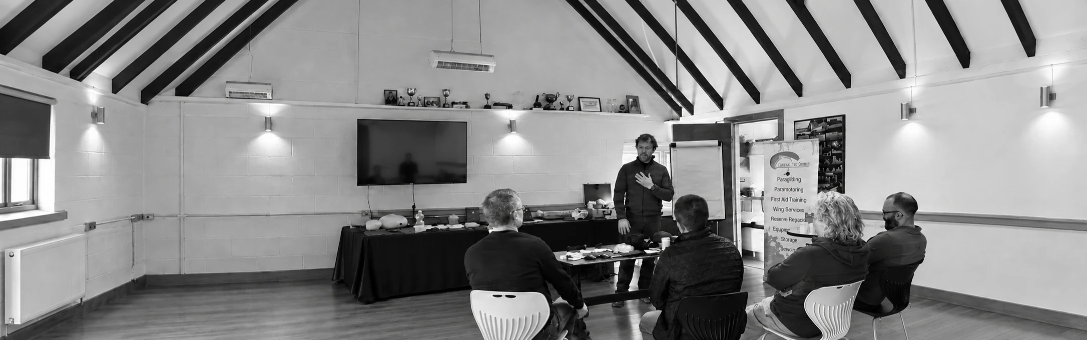 An instructor leading a first aid classroom session with four seated participants