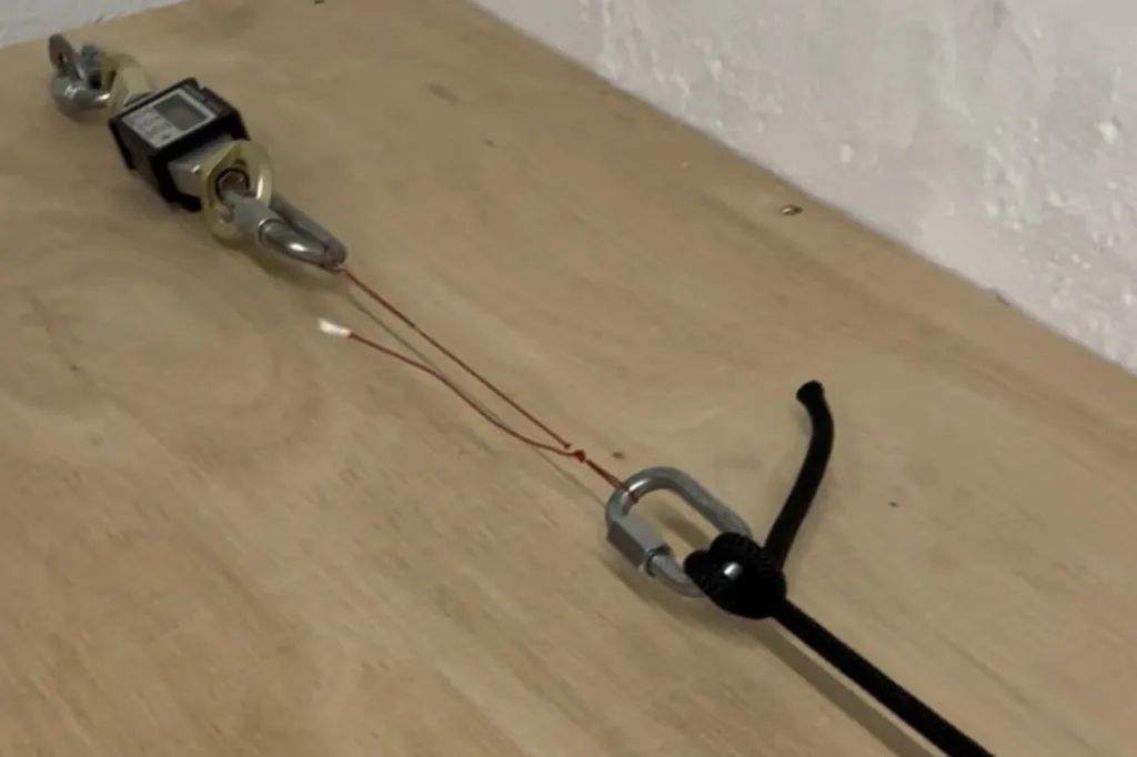 A paraglider line connected to a calibrated load testing cell