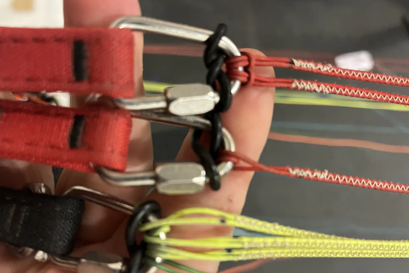 Close view of paraglider risers, maillons and line attachments