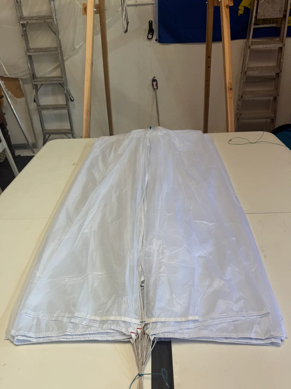 White reserve canopy panels laid out and aligned on the packing table in the BTC workshop
