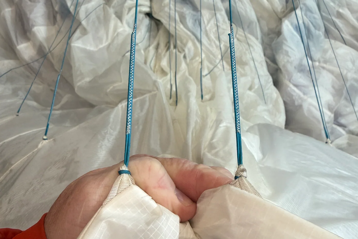Matching paraglider line attachment points held side by side for a symmetry check